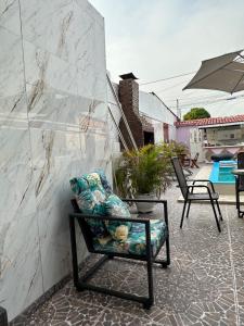 a chair sitting on a patio next to a wall at Residencial Napolitan in Manaus