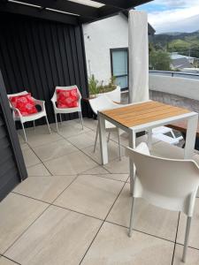 a patio with a table and chairs on a roof at Reefers in Kuaotunu