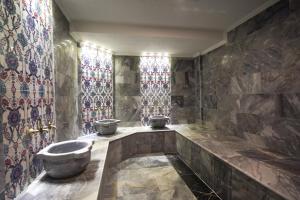 a bathroom with a tub and stained glass windows at Ugurlu Hotel in Gaziantep