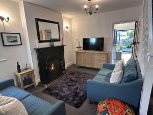sala de estar con sofá azul y chimenea en 18 Rose Hill in Central Beaumaris, en Beaumaris