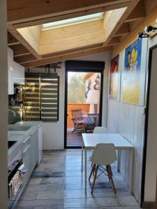 uma cozinha com uma mesa e uma sala de jantar em Loft Cosy " Le Flamant Rose " em Fréjus