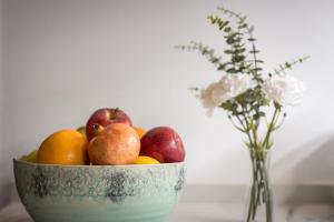 a bowl of fruit on a table with a vase of flowers at L’Angorfa de Casa Santiago, casa rural in Tivenys
