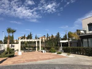 dziedziniec z białą pergolą i budynek w obiekcie Villa Tindra w mieście Torrevieja