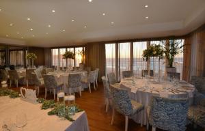 a banquet room with tables and chairs with white tablecloths at Lagoon Beach Hotel & Spa in Cape Town +119 photos