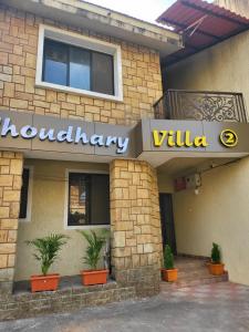 a restaurant with a sign on the side of a building at THE PERFECT STAYS: CHOUDHARY VILLA in Lonavala