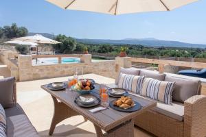 a table with a bowl of fruit on a patio at Villa Niragia with Magnificent view in Astérion