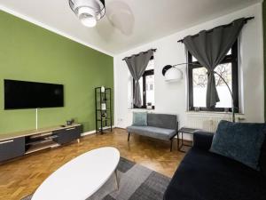 uma sala de estar com um sofá e uma televisão de ecrã plano em Erstklassige 3-Zimmer Wohnung em Leipzig
