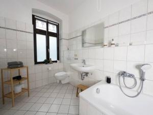 uma casa de banho com uma banheira, um lavatório e um WC. em Erstklassige 3-Zimmer Wohnung em Leipzig