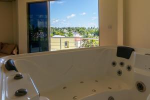 a bathroom with a bath tub with a large window at Blue Wave Hotel Maldives for SURF, FISHING and Beach in Kudahuvadhoo