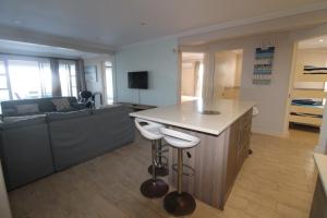 een woonkamer met een bank en een keuken met een aanrecht bij Vista Del Mar 1 in Saint Michaelʼson Sea
