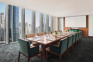 Anantara Downtown Dubai في دبي: قاعة اجتماعات مع طاولة طويلة وكراسي خضراء