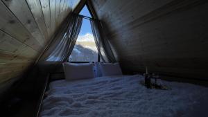 un letto in una camera con una grande finestra di view a Kazbegi
