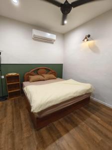 a bedroom with a bed with a wooden head board at Wellson Home Ipoh14px 怡保中古风5间房民宿 in Ipoh