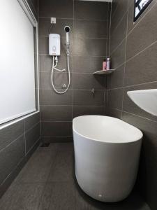 a bathroom with a white tub and a sink at Wellson Home Ipoh14px 怡保中古风5间房民宿 in Ipoh