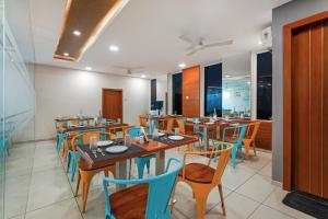 a restaurant with wooden tables and blue chairs at Westside Hotel Gachibowli in Hyderabad