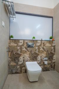 a bathroom with a toilet and a stone wall at Westside Hotel Gachibowli in Hyderabad