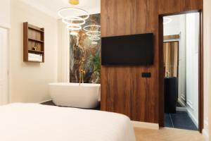 a bedroom with a bed and a tv on a wall at Onix Residence in Baia Mare