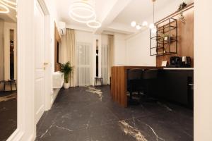 pasillo con suelo de mármol y escritorio en una habitación en Onix Residence, en Baia Mare