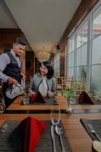 un homme et une femme assis à une table dans un restaurant dans l'établissement PETIT BOUTIQUE HOTEL SOLO, à Solo