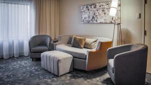 a living room with two chairs and a chair and a couch at Courtyard by Marriott Norman in Norman