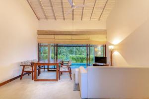 comedor con mesa y sofá en Celestial Hills - Villas & Suites by The Clarks, en Kandy