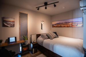 a bedroom with a bed and a desk with a computer at Modern Container House - 2 Min Walk to Matsubara Beach - Sleeps 7 in Tsuruga