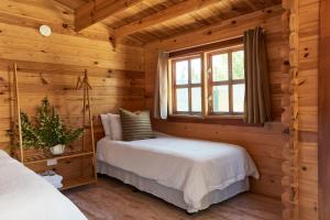 Tenterfield Lodge Caravan Park في تينتيرفيلد: غرفة نوم مع سرير في كابينة خشب