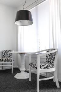 a white table and chairs with a lamp and window at Sole East Beach in Montauk