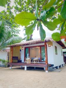 une petite maison avec un banc devant elle dans l'établissement V-View Beach Resort, à Baan Tai