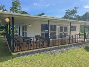 uma casa com um alpendre com cadeiras e uma cerca em Aunty Fou's Home - Vaivase em Apia