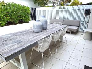 a wooden table and chairs with vases on it at Palm Beach Lux Villa in Gold Coast
