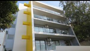 a tall white building with a balcony at Ivy League House, Pyramid Residency in New Delhi