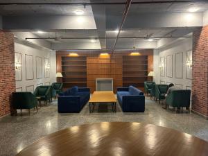 une salle d'attente avec des chaises bleues, une table et un paravent dans l'établissement Ivy League House, Pyramid Residency, à New Delhi