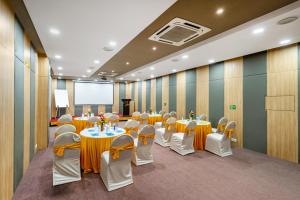 a conference room with tables and chairs and a screen at WESTSIDE HOTEL HiTECH CITY in Hyderabad