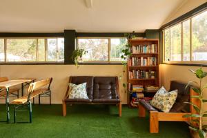 a living room with two leather chairs and a book shelf at Tenterfield Lodge Caravan Park in Tenterfield