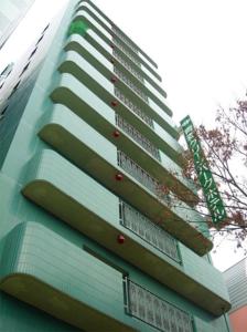 wysoki budynek z znakiem na boku w obiekcie Aomori Green Park Hotel w mieście Aomori