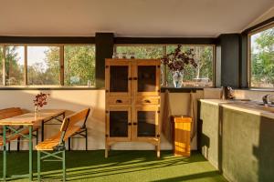 cocina con mesa y mesa y algunas ventanas en Tenterfield Lodge Caravan Park en Tenterfield