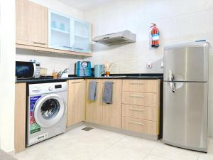eine Küche mit einem Kühlschrank und einer Waschmaschine in der Unterkunft Dubai Marina Oasis Studio near in JBR in Dubai