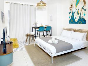 Schlafzimmer mit einem Bett, einem TV und einem Tisch in der Unterkunft Dubai Marina Oasis Studio near in JBR in Dubai