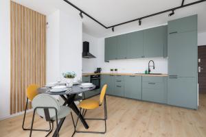 a kitchen and dining room with a table and chairs at Stylish Apartment with Parking in Katowice by Renters in Katowice