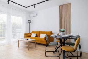 a living room with a yellow couch and a table at Stylish Apartment with Parking in Katowice by Renters in Katowice