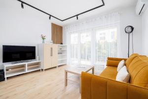 a living room with a couch and a tv at Stylish Apartment with Parking in Katowice by Noclegi Renters in Katowice