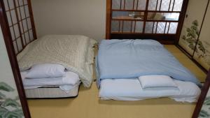 a room with two beds with pillows on the floor at Yagisawa Home - Vacation STAY 67831v in Nikko