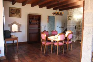 uma sala de jantar com uma mesa e cadeiras cor-de-rosa em Maison em Saint-Priest-de-Gimel