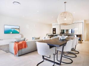 a kitchen and living room with a wooden table and chairs at Palm Beach Lux Villa in Gold Coast