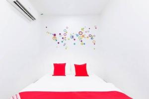 una camera da letto con un letto bianco con cuscini rossi di SAND HOTEL a Kuala Lumpur