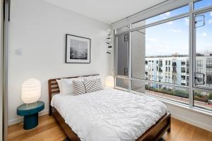 una camera con un letto e una grande finestra di Iconic Downtown Living! 1bedroom, Gym, Rooftop Patio. a Victoria