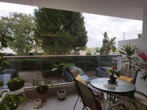 balcón con mesa, sillas y plantas en חדר מקסים בדירה בה אנו גרים בחולון קרוב לתל אביב וחוף הים כולל מקלט, en Jolón