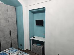 a bedroom with a blue wall with a desk and a tv at Ma Maison Iris in Turin