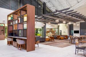 a large lobby with a table and chairs and tables at Candlewood Suites - Roanoke Airport in Roanoke